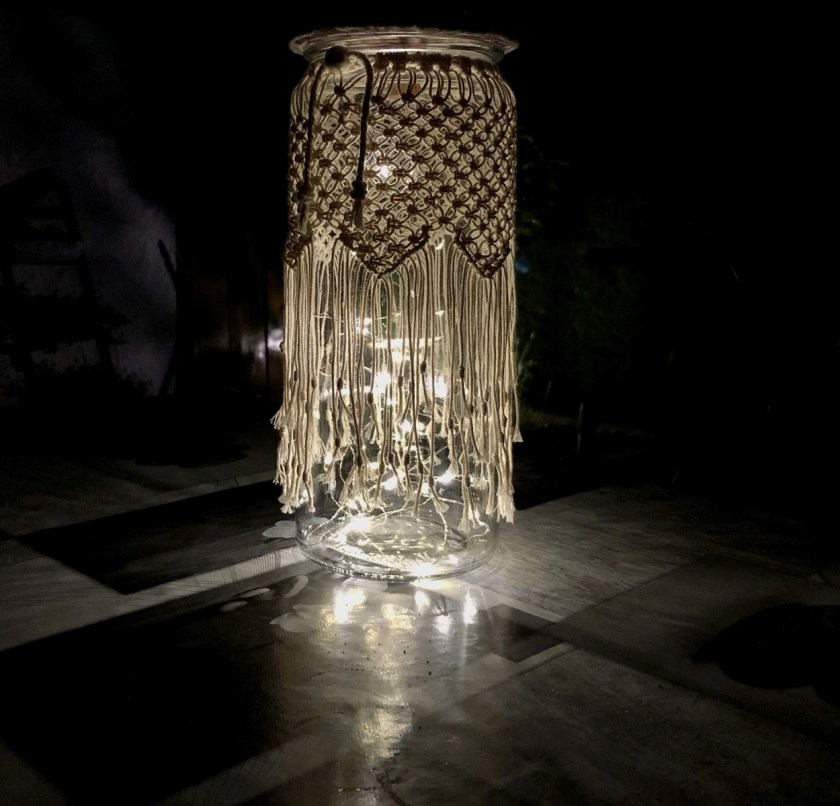 Für Balkonromantik benötigst du: Eine leere Flasche mit großen Öffnung, ein selbstgebastelter Deckel, ein geknüpftes Netz und eine Lichterkette 